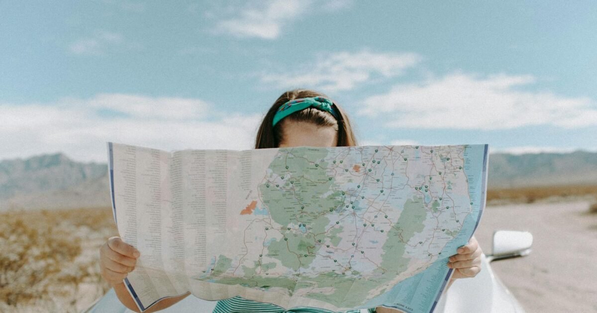 A woman holds a map while traveling through the scenic desert of California, USA.