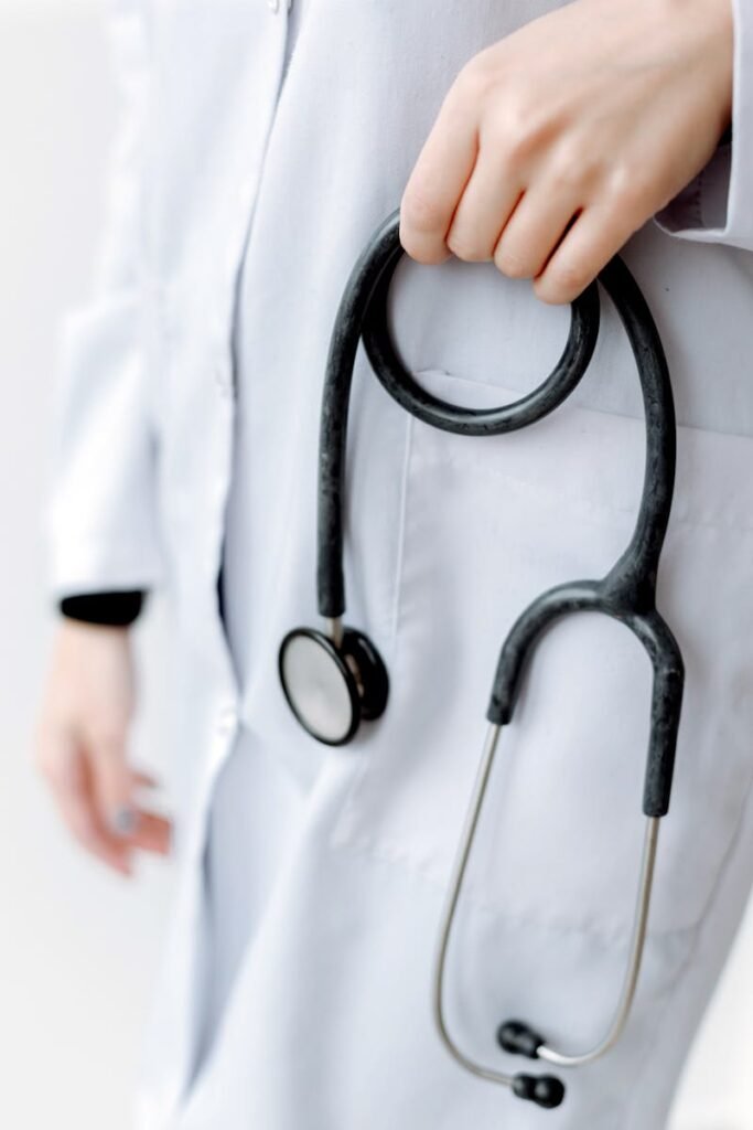 Close-up of a doctor holding a stethoscope, showcasing professional medical attire.