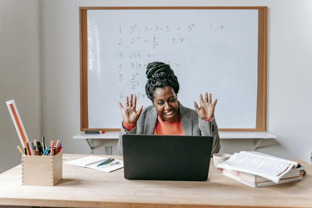 Smiling teacher enjoying an online math class with equations on whiteboard.