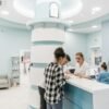 Bright, welcoming clinic reception with patients interacting with staff for registration.