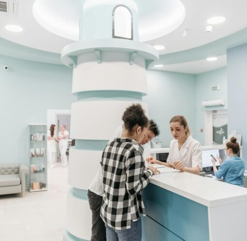 Bright, welcoming clinic reception with patients interacting with staff for registration.