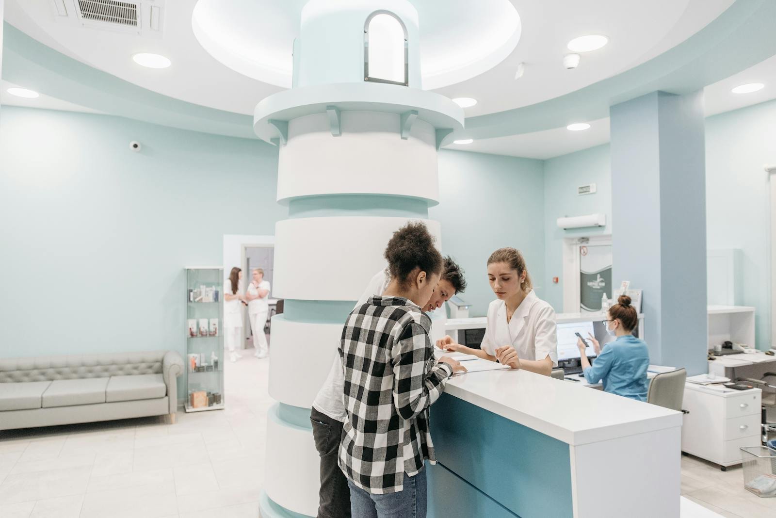 Bright, welcoming clinic reception with patients interacting with staff for registration.