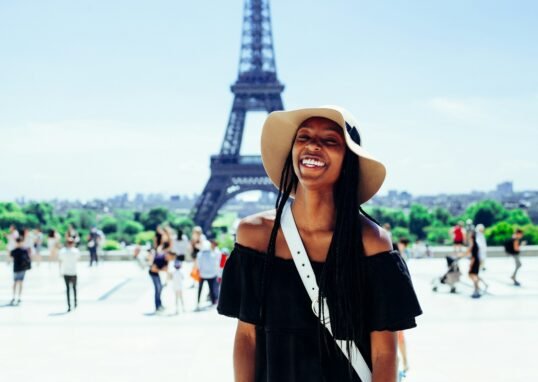 woman standing behind Eiffel Tower during daytime