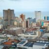 Panoramic view of Durban's modern skyline showcasing high-rise buildings and ocean backdrop.