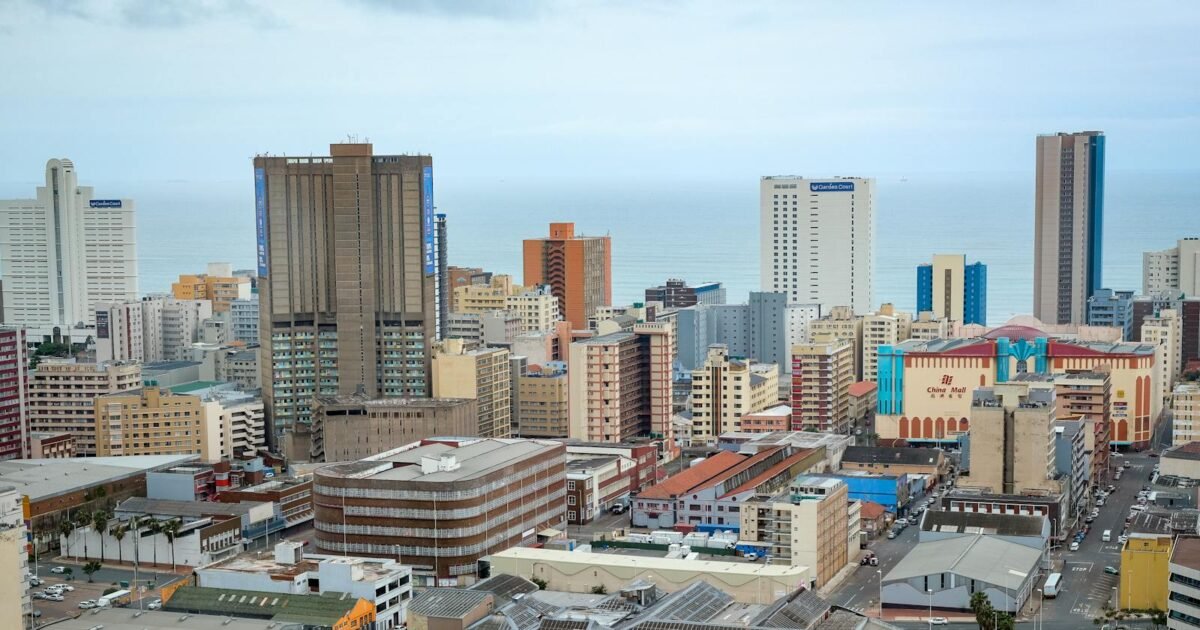 Panoramic view of Durban's modern skyline showcasing high-rise buildings and ocean backdrop.